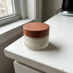 The balm jar with a terracotta lid on a white counter